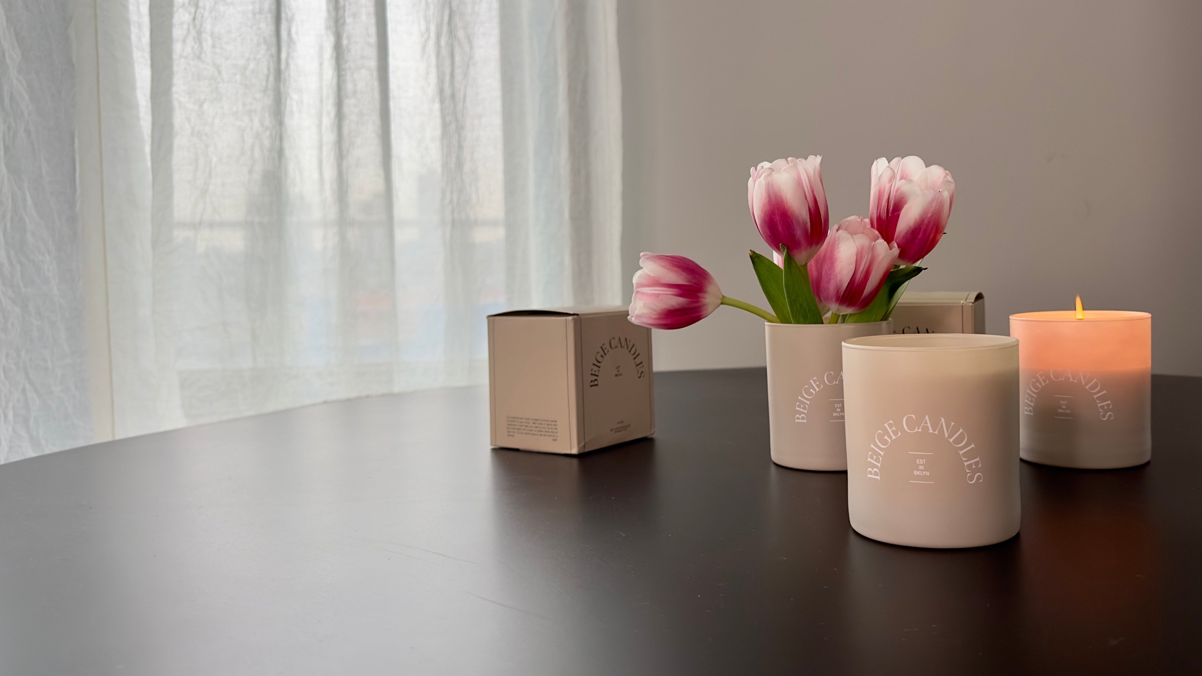 Candles and tulips on a table with a neutral background